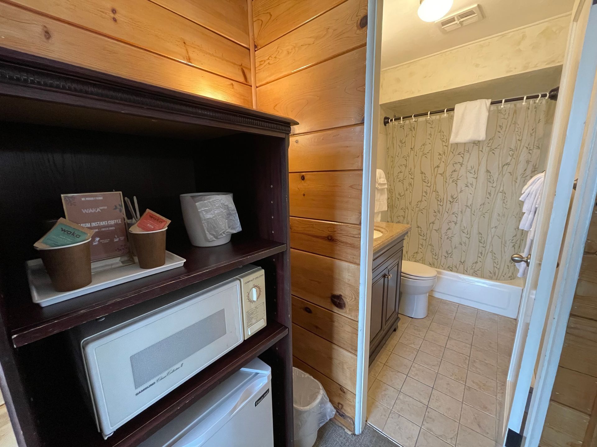 There is a microwave and a refrigerator in the bathroom.