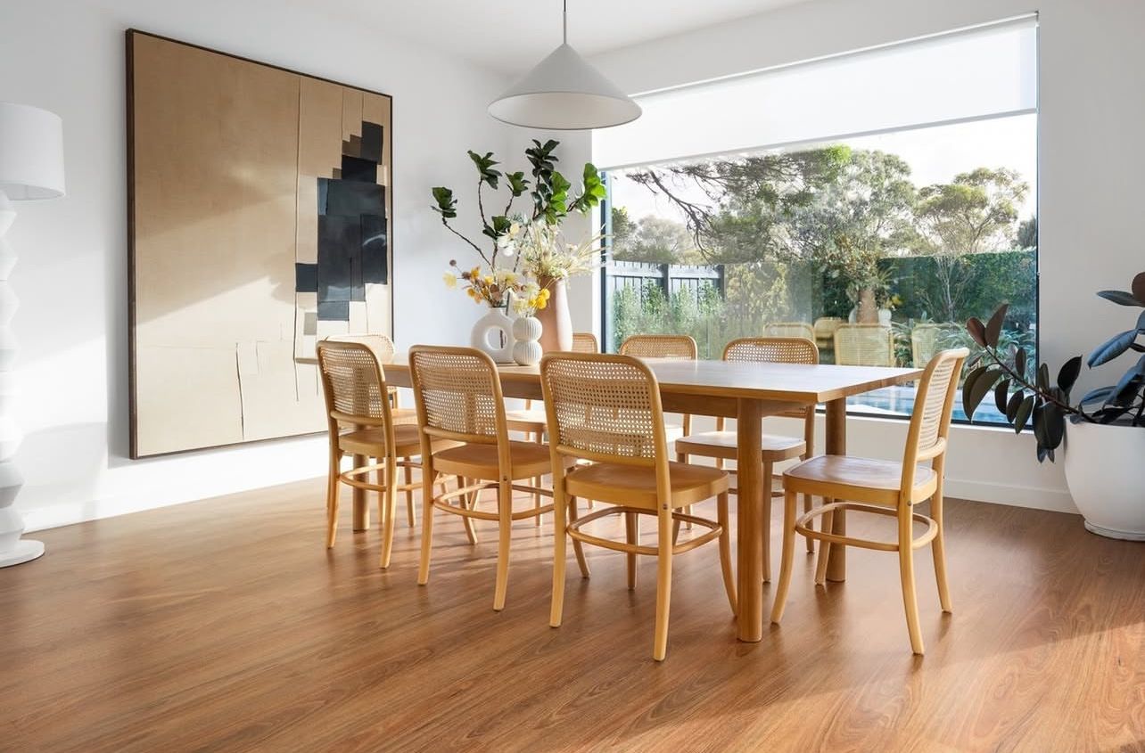 A Living Room with Hardwood Floors, a Couch, Two Tables and A Painting on The Wall — Kelwin Coastal Carpets In Kundra Park, QLD