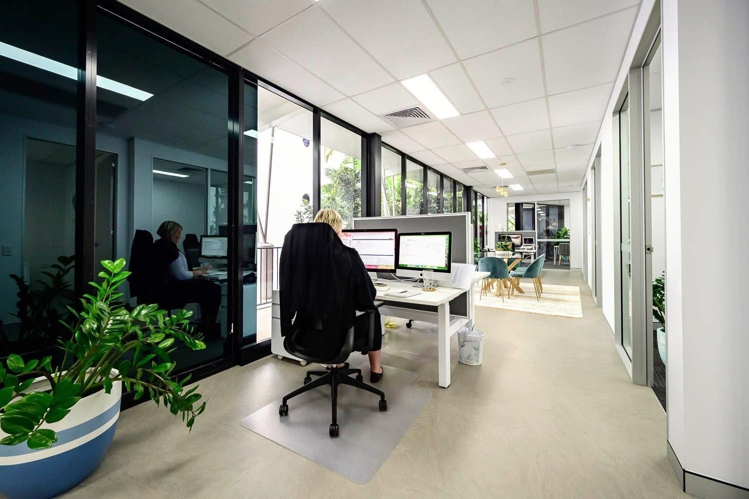 Empty cafe with tables, chairs, and tall windows overlooking a bright outdoor scene — Kelwin Coastal Carpets In Kundra Park, QLD