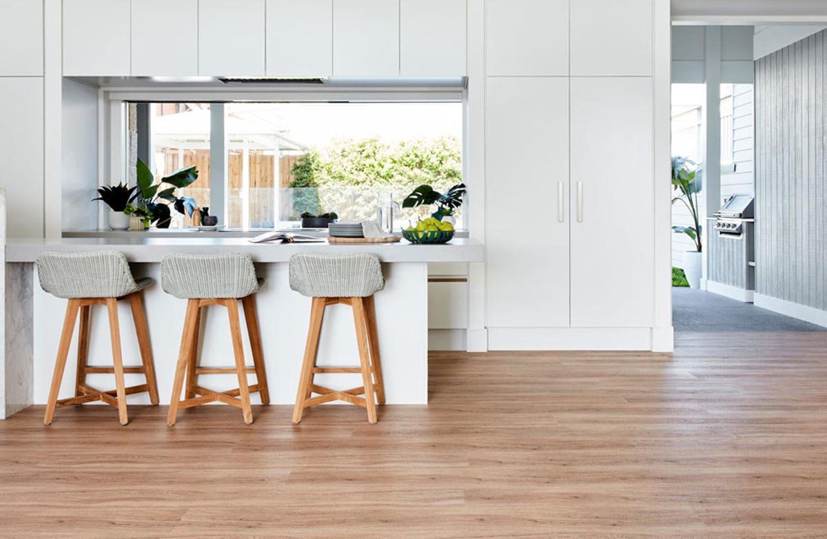 A Kitchen with White Cabinets, Wooden Floors and Stools — Kelwin Coastal Carpets In Gympie, QLD
