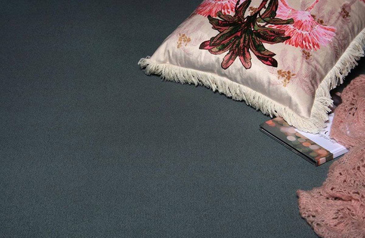 A Pillow with A Flower on It Is on The Floor Next to A Book — Kelwin Coastal Carpets In Kundra Park, QLD