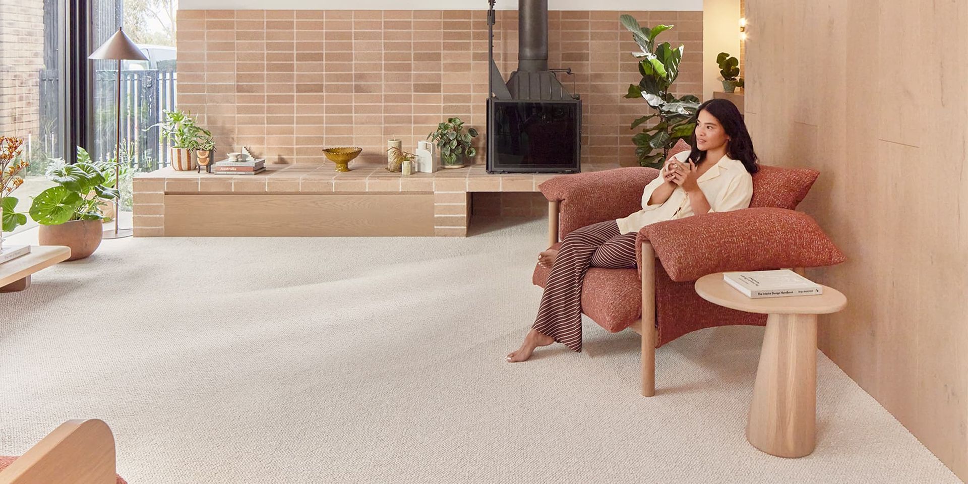 Man Smiling In Front of A Warehouse Filled With Rolls Of Carpet — Kelwin Coastal Carpets In Kundra Park, QLD