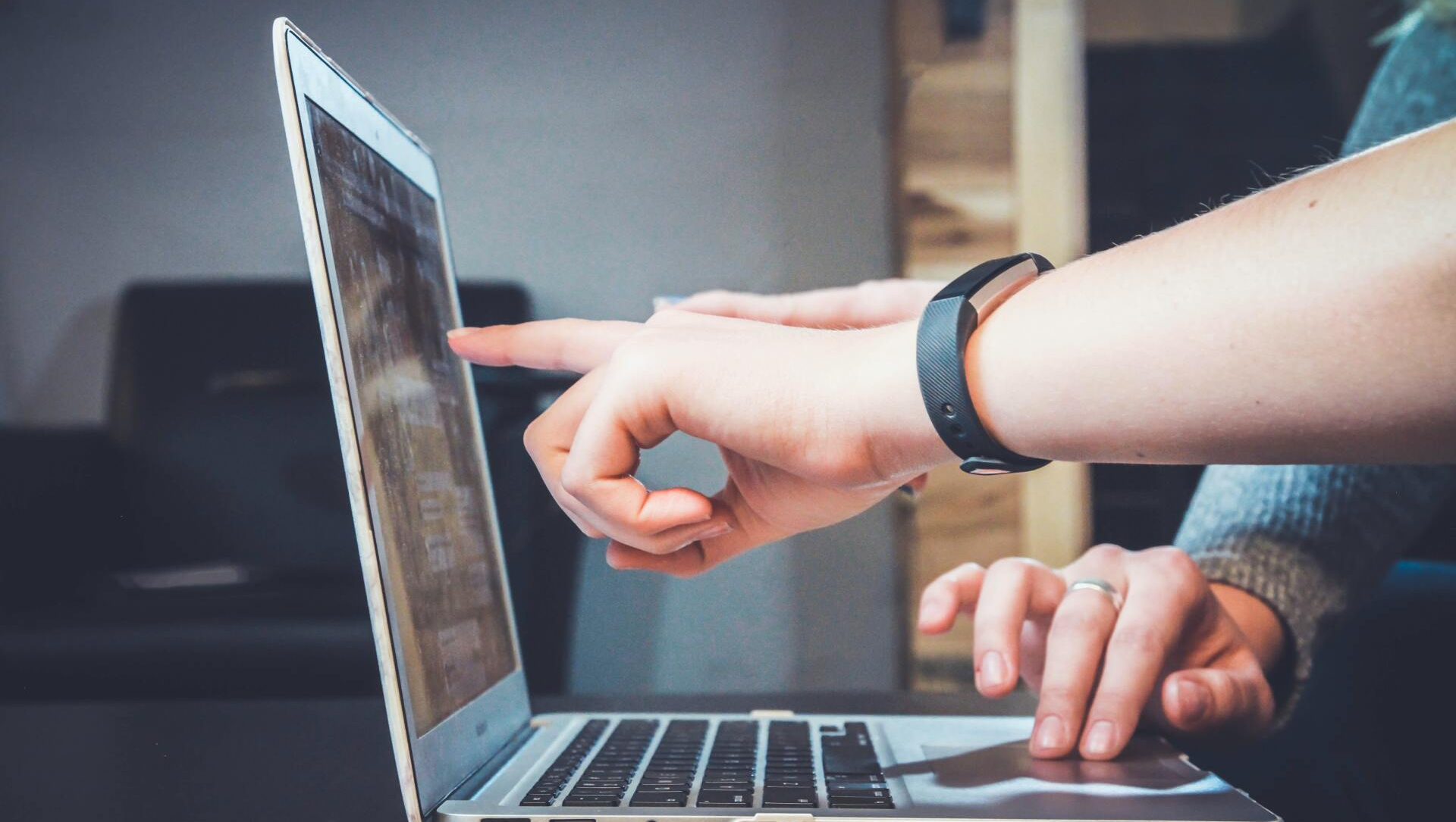 People pointing at laptop