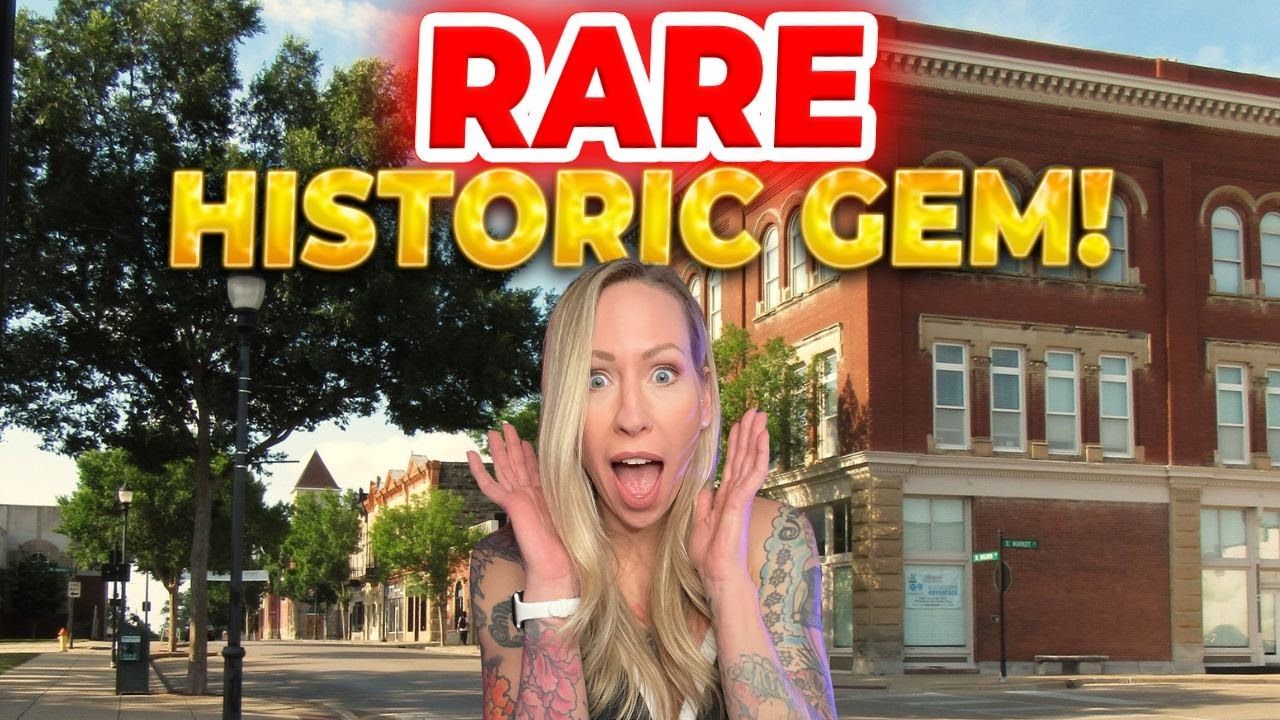 A woman is standing in front of a building that says rare historic gem