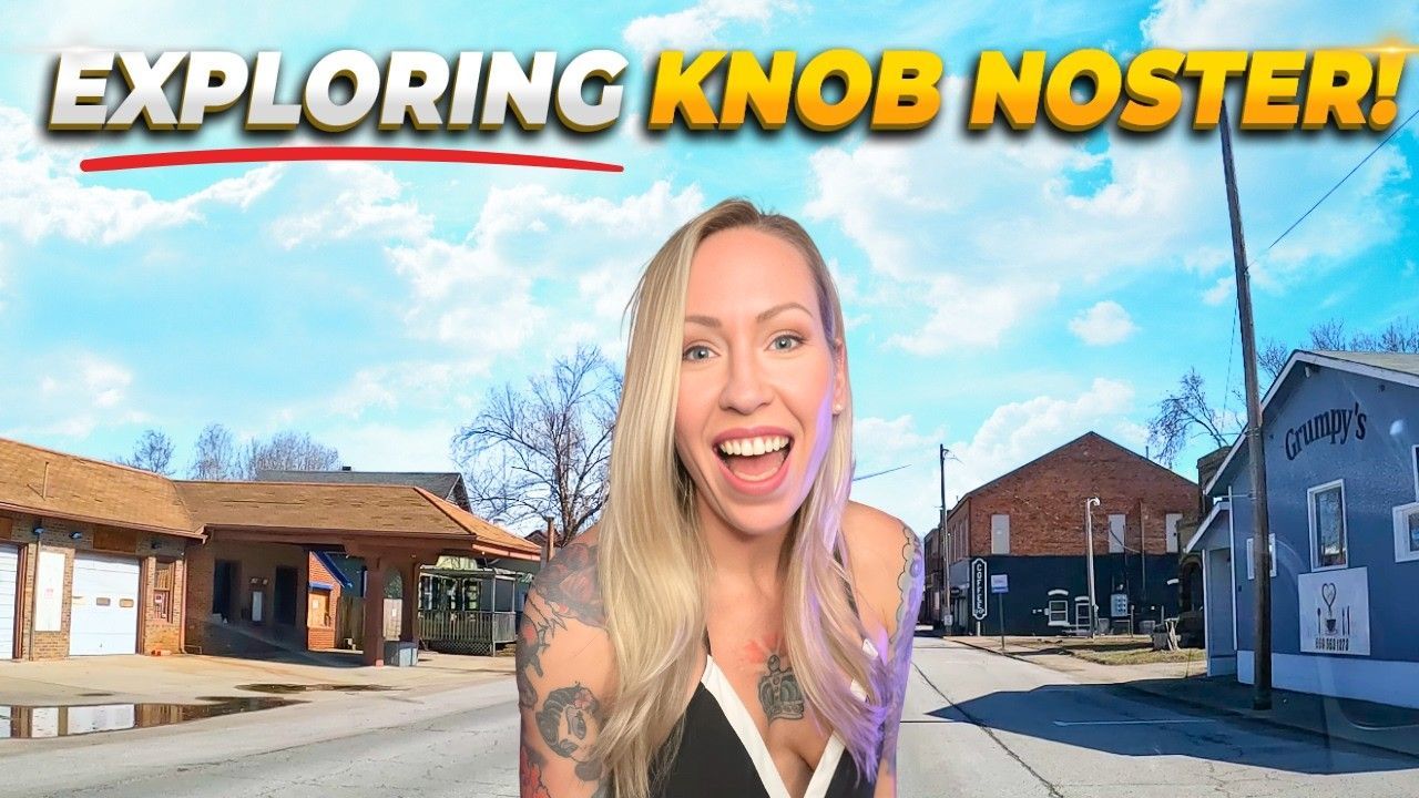 Blonde woman smiling excitedly in Knob Noster, Missouri, with buildings in the background. Title: 