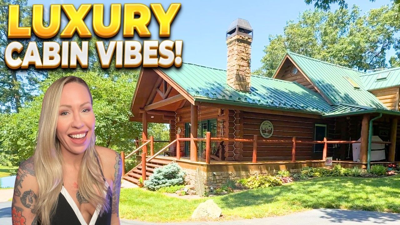 Woman smiles in front of a luxury cabin with a green roof and stone chimney. 