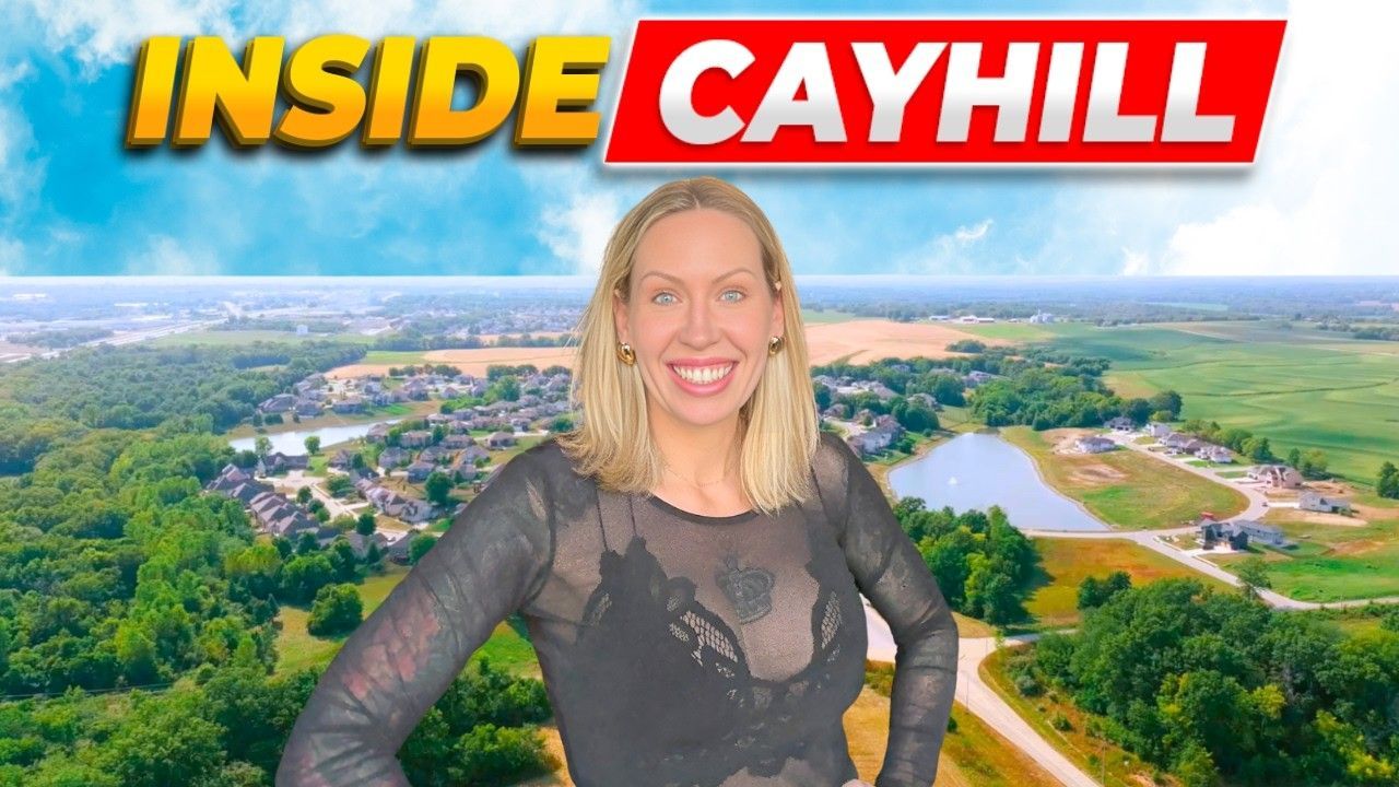 A woman smiling in front of a digital backdrop showing an aerial view of the Cayhill community under a blue sky.
