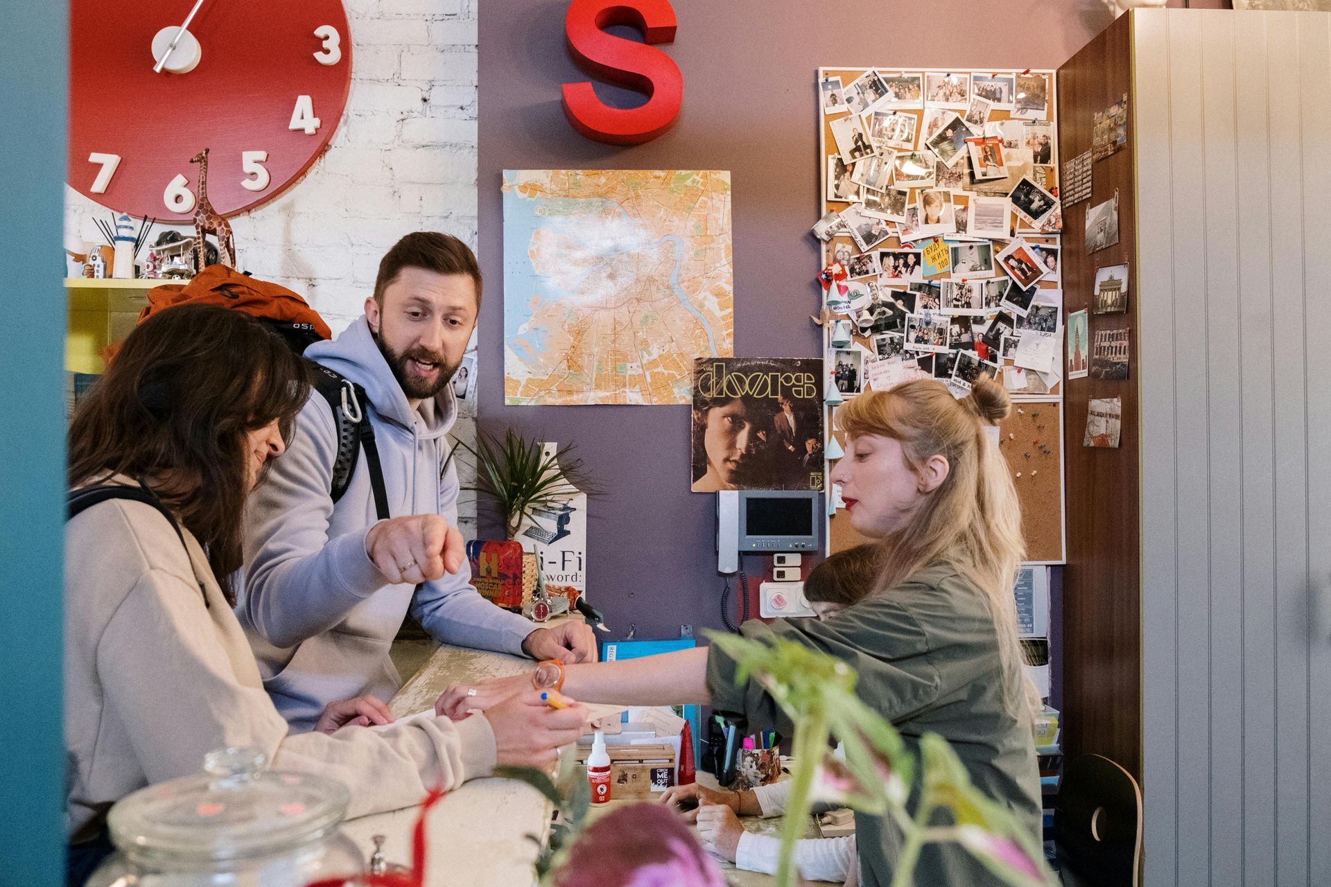 A group of people are sitting at a table in front of a clock.