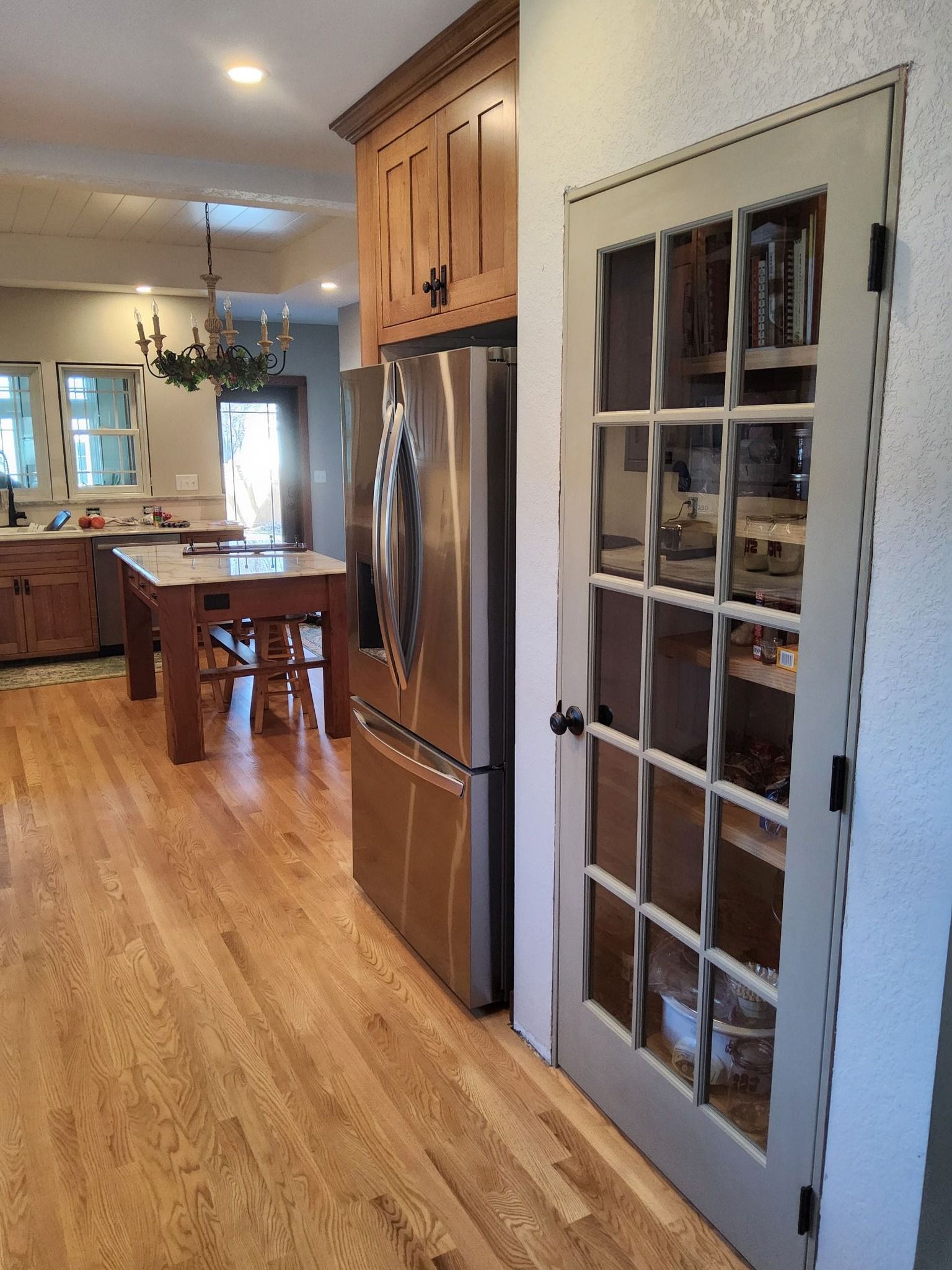 A kitchen with hardwood floors and a stainless steel refrigerator