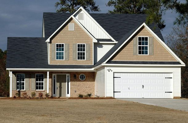 A house with a white garage door and a black roof