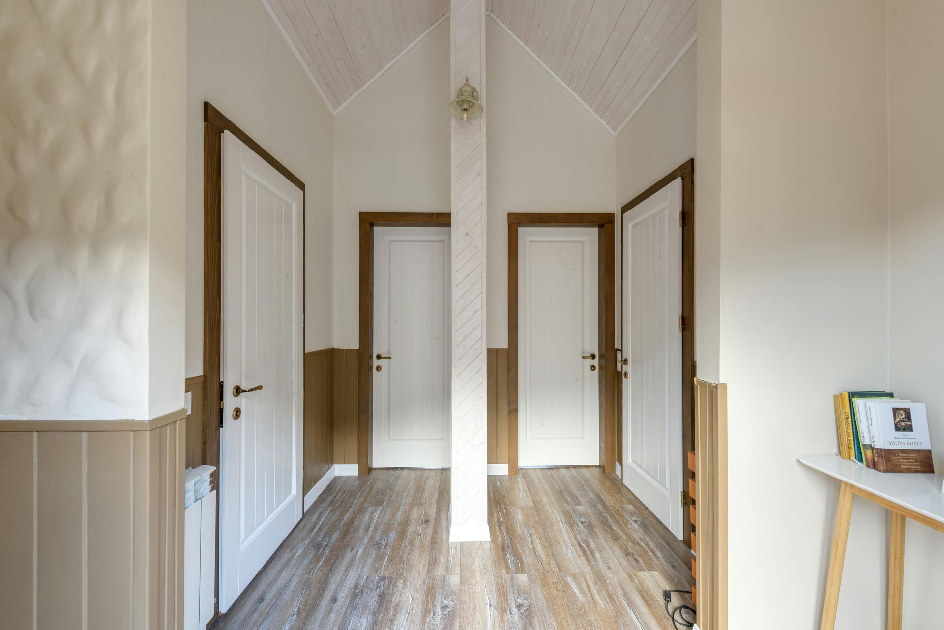A hallway with wooden floors and white doors in a house.