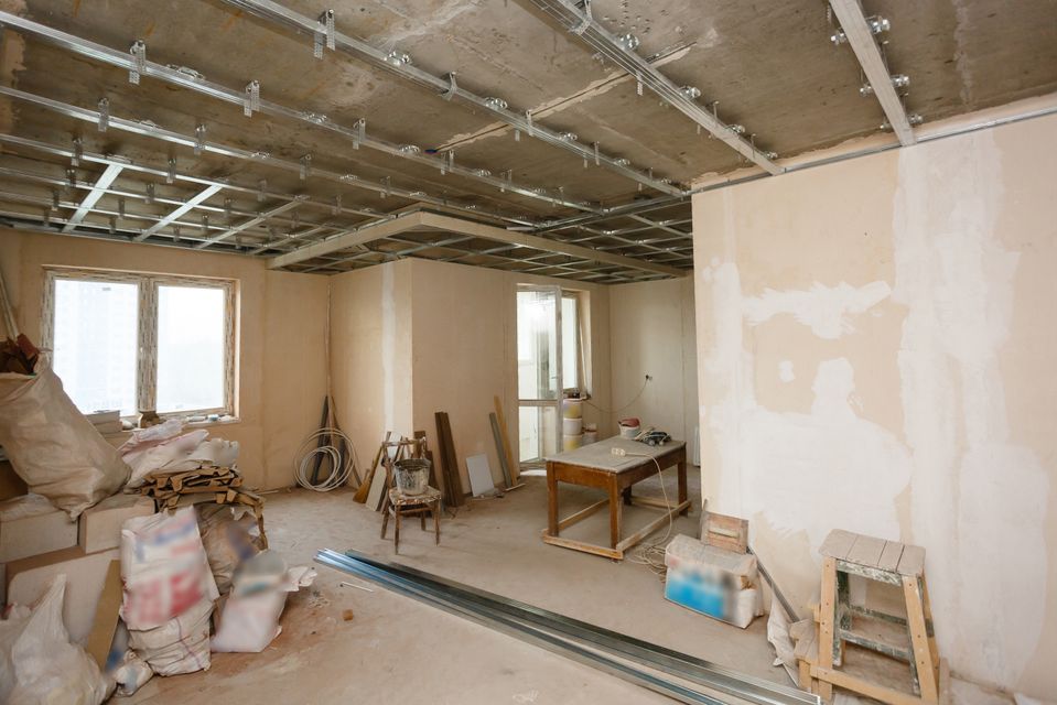 A room under construction with a table and chairs in it.