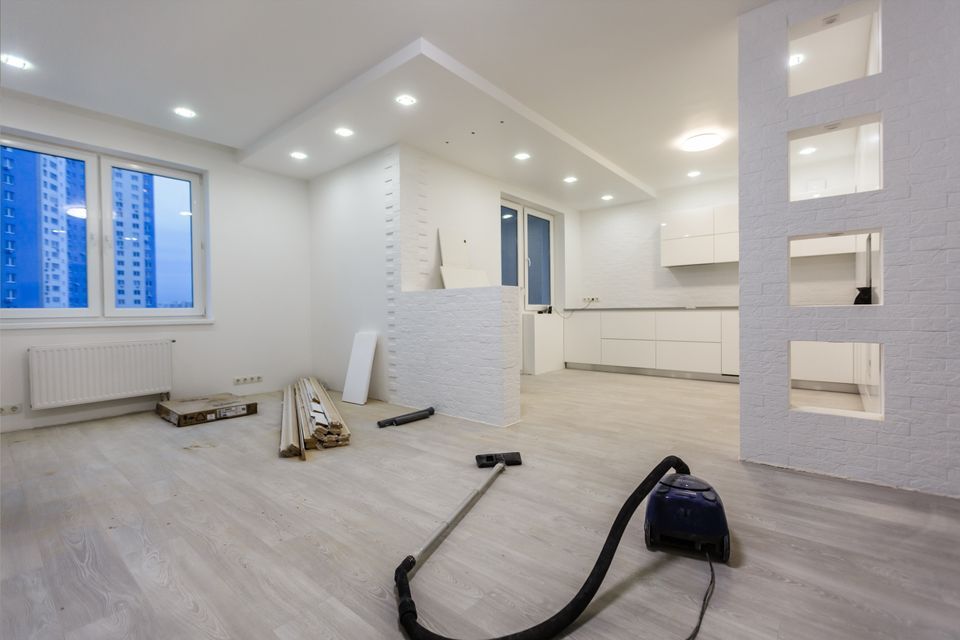 An empty room with a vacuum cleaner on the floor.