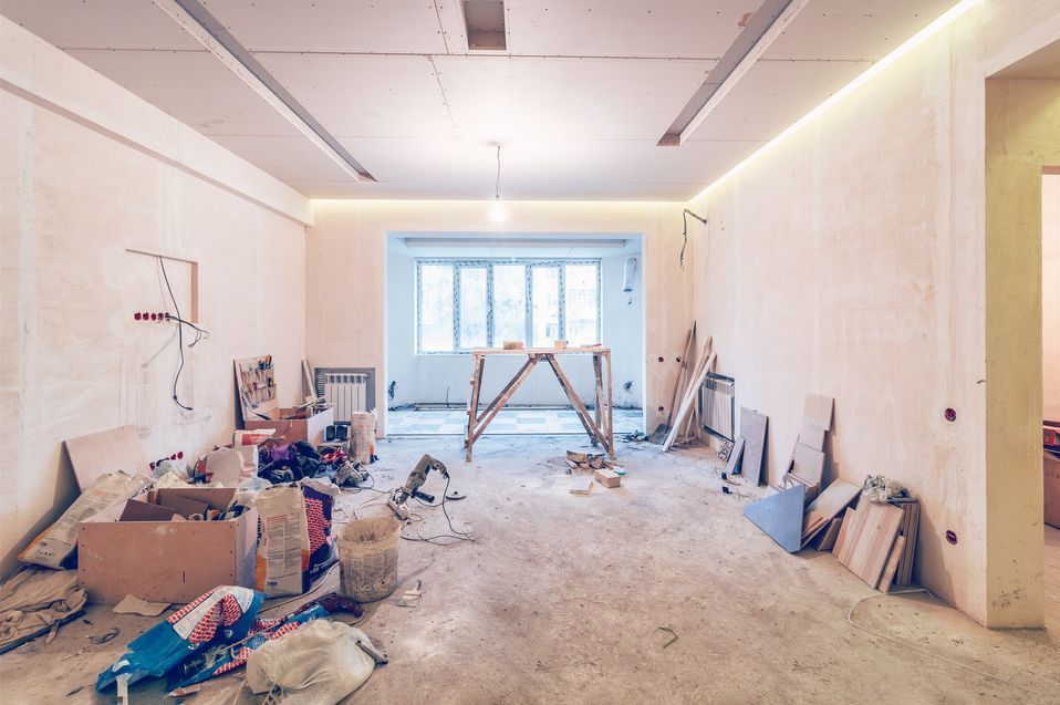 A living room under construction with boxes and scaffolding on the floor.