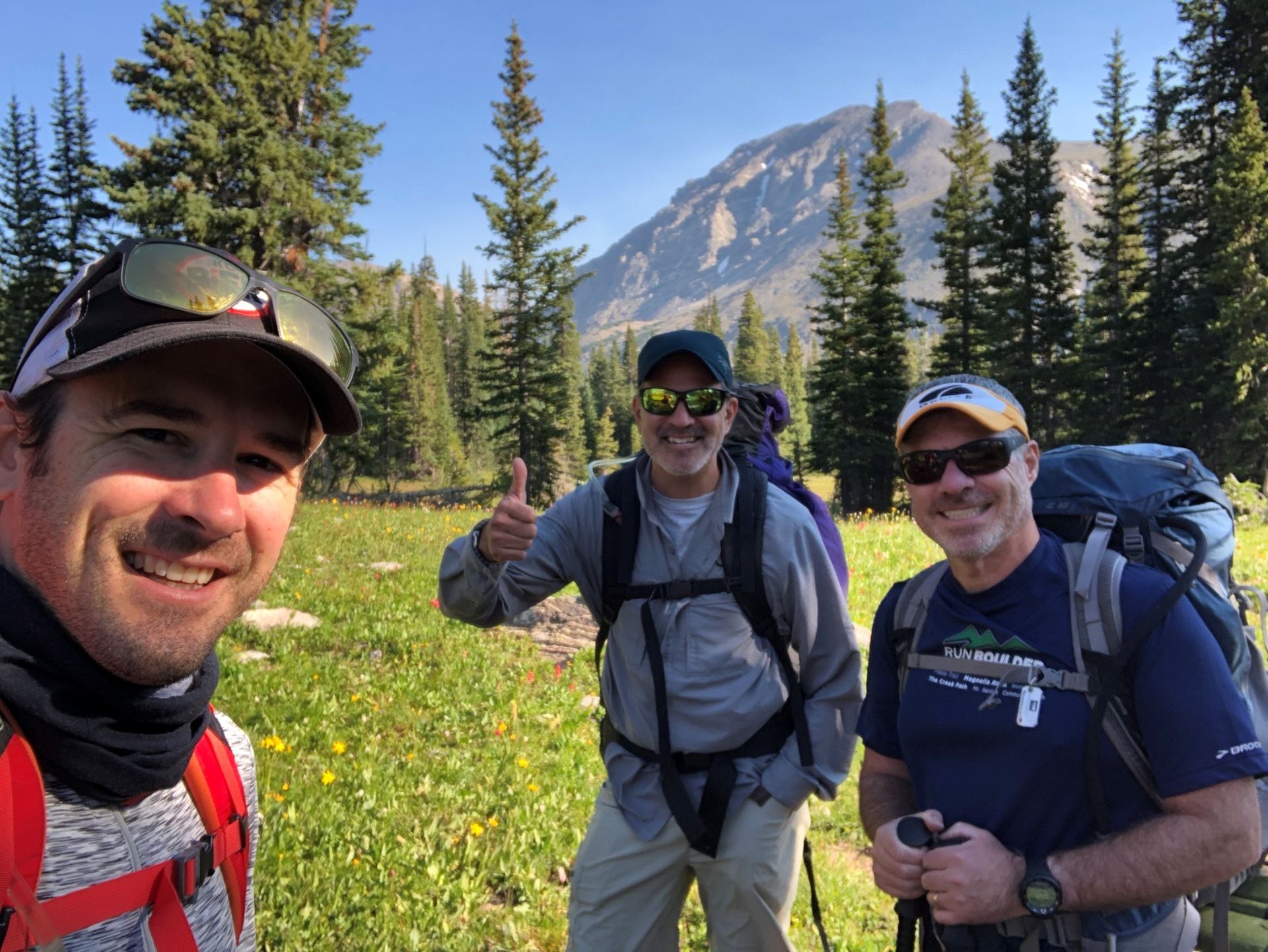 A group of people are putting their hands together on a wooden table.
