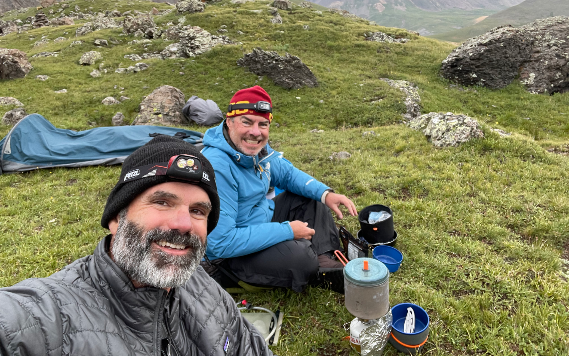 A small green seedling growing out of a pile of dark brown soil.