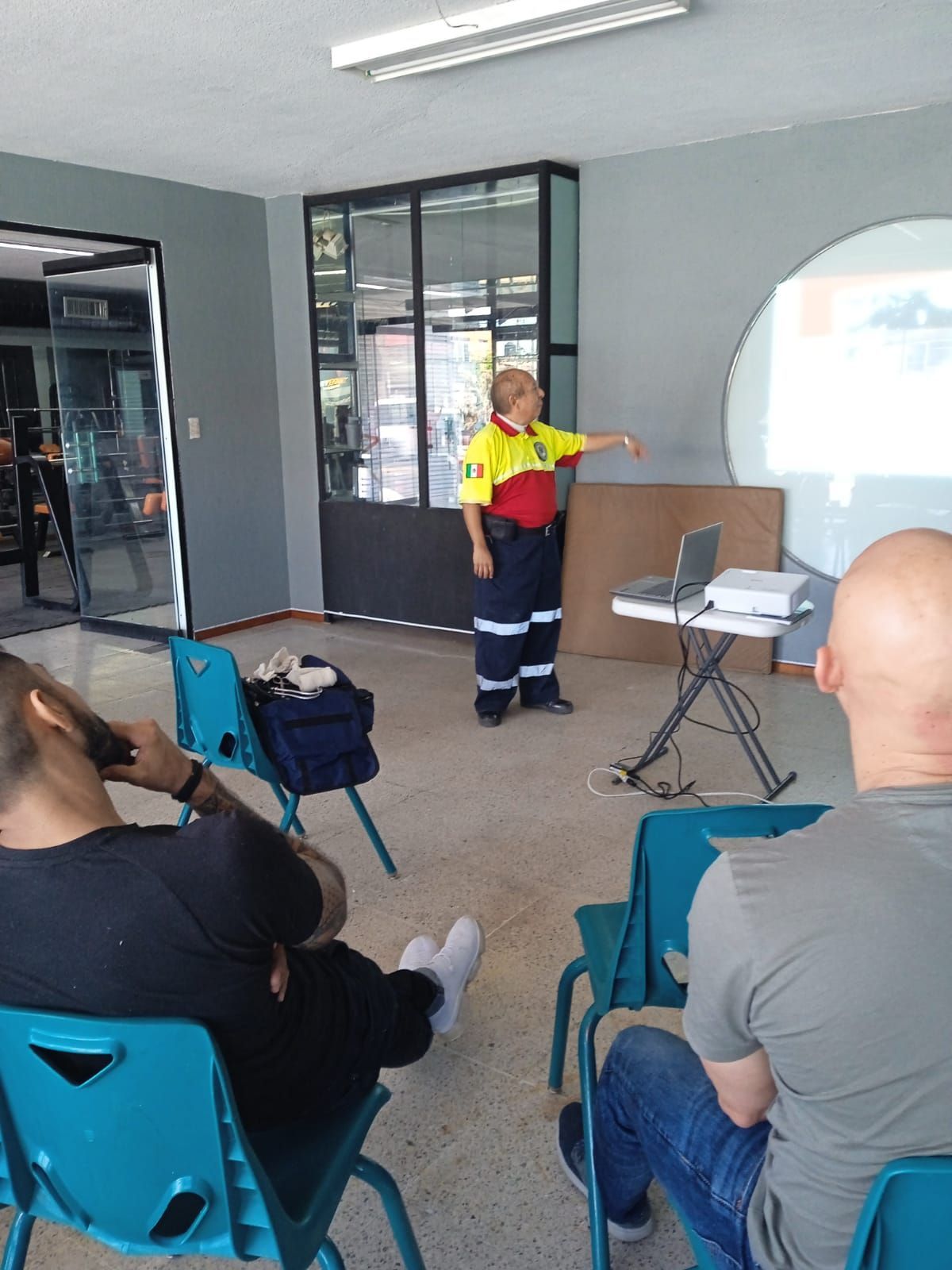 Una mujer está dando una presentación a un grupo de personas sentadas en sillas.
