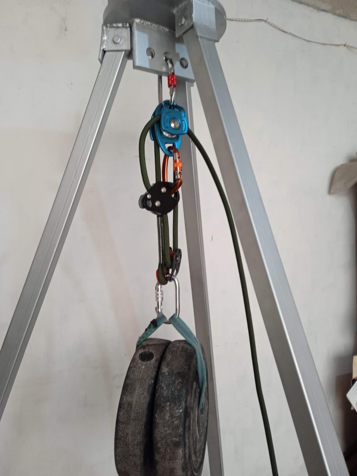 Un trípode con una polea unida a él.