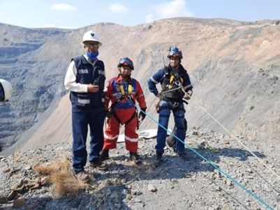 Un grupo de personas están paradas en la cima de una montaña sosteniendo cuerdas.