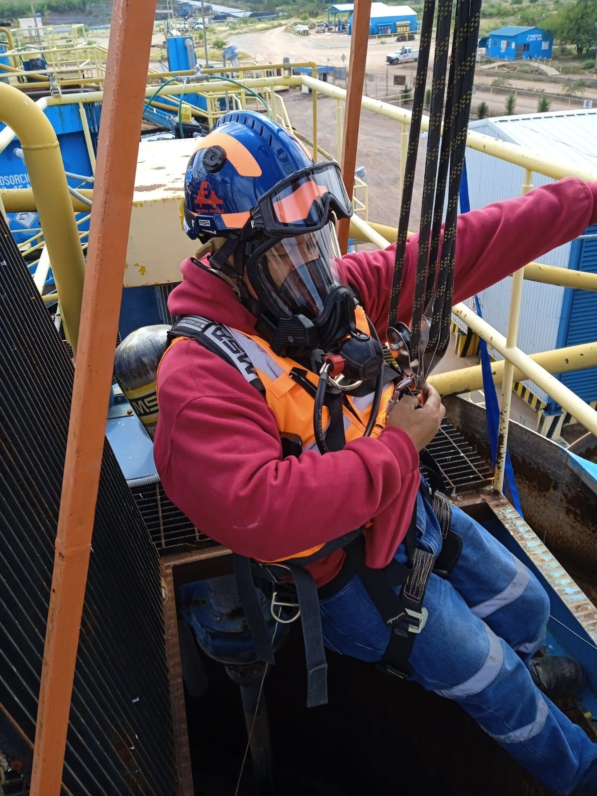 Un hombre que lleva casco y gafas está sentado en una escalera.