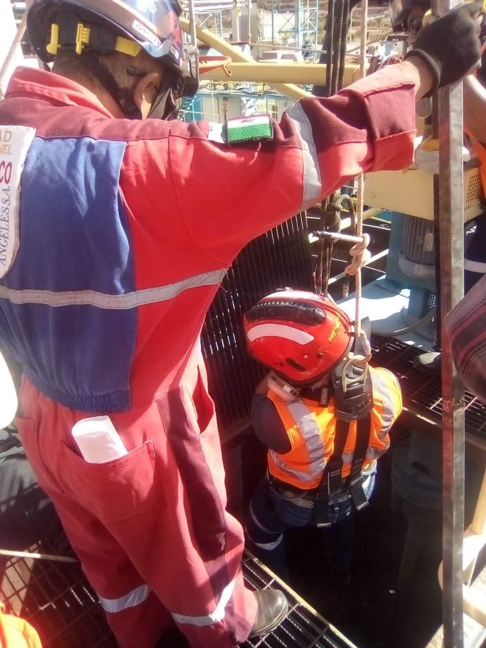 Un hombre con un mono rojo y azul está trabajando en una máquina.
