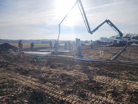 A concrete pump is being used to pour concrete on a construction site.