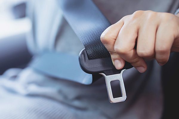 A person is putting on a seat belt in a car. | Carmasters Automotive