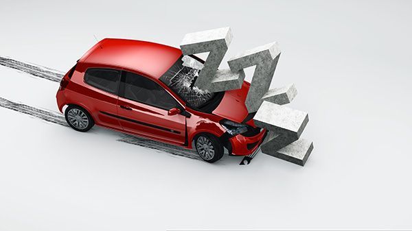 A red car is being crushed by concrete blocks. | Carmasters Automotive