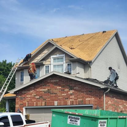 A couple of men are working on the roof of a house.