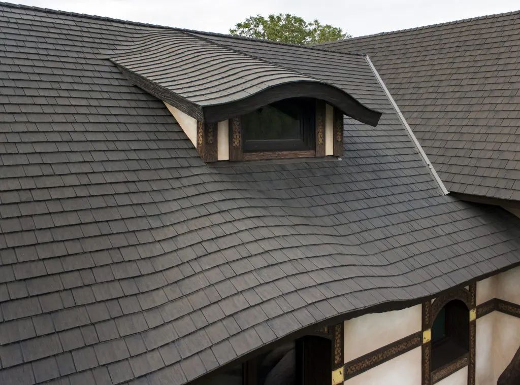 Dark gray shingled roof with a dormer window; building exterior with white trim.