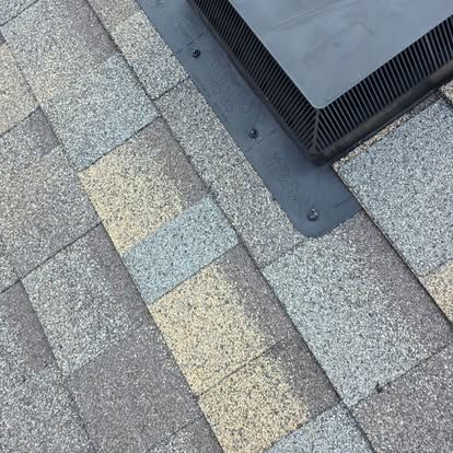 A close up of a roof with a drain on it.