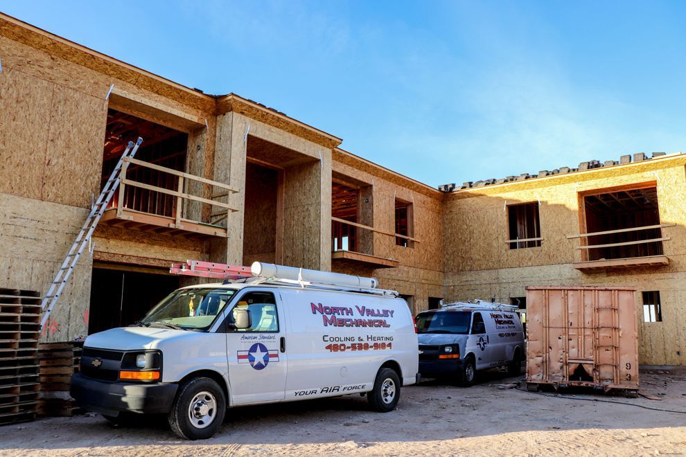 A white van is parked in front of a building under construction