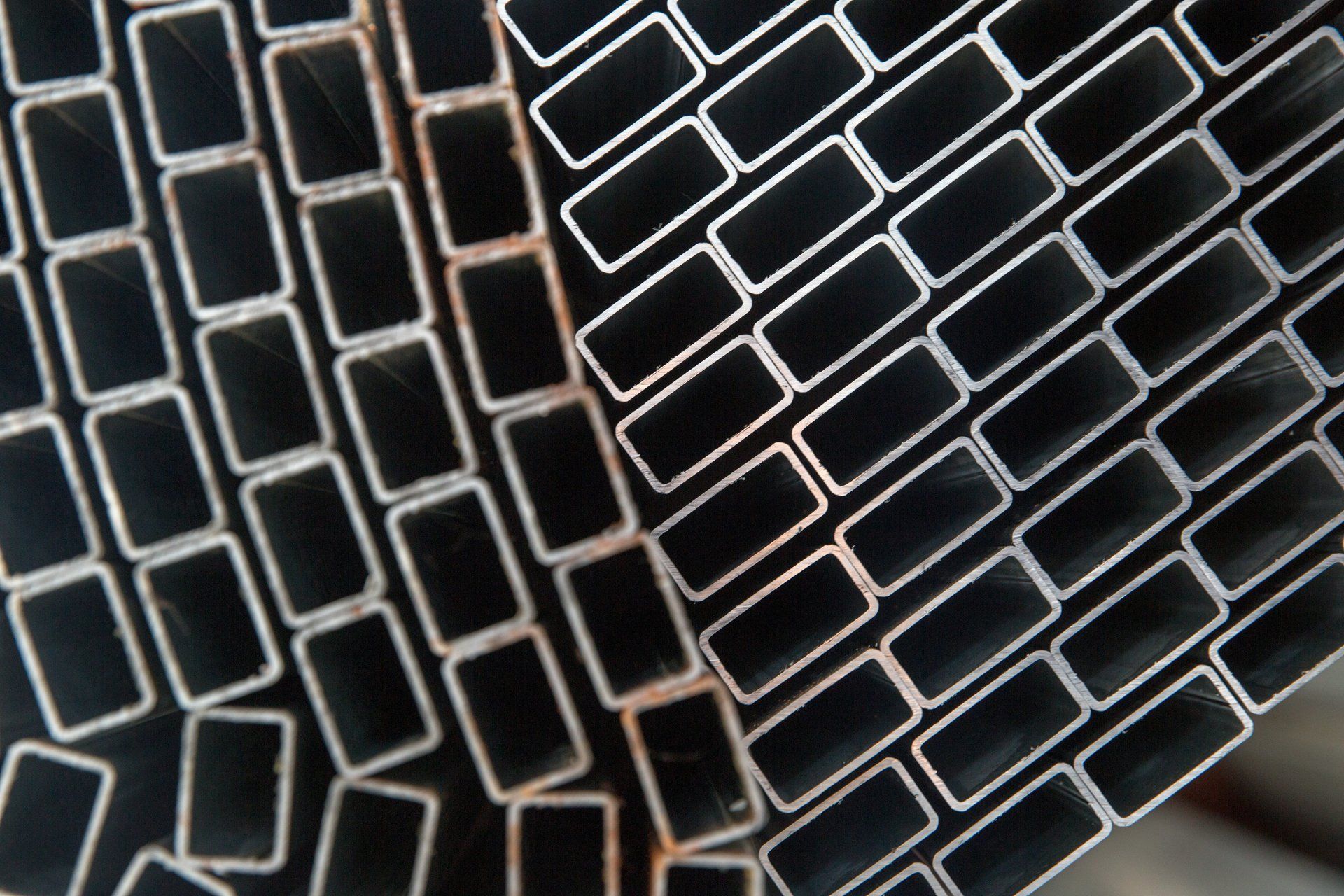 Pile di tubi metallici rettangolari, leggermente inclinati.