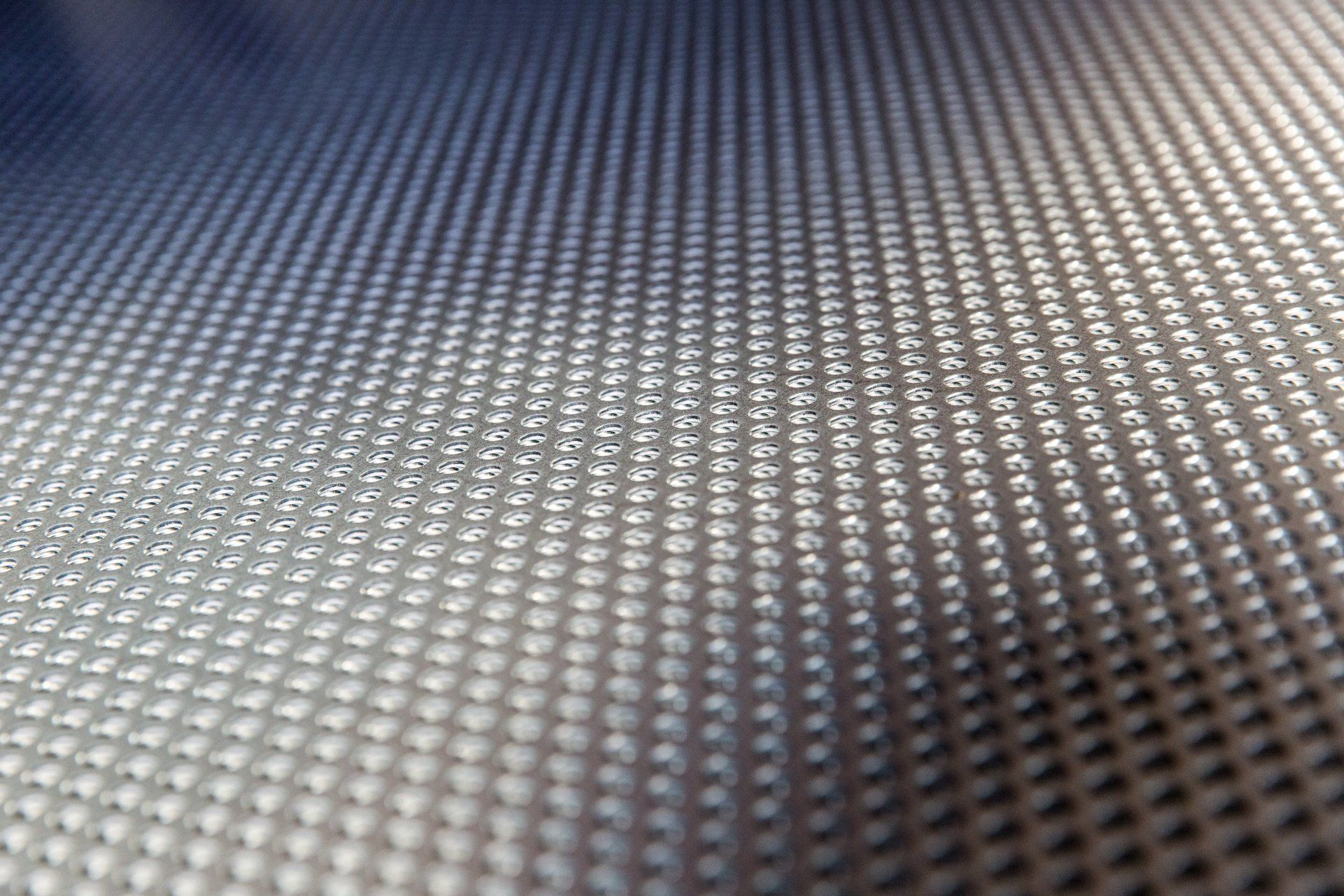 Superficie argentata testurizzata con un motivo di piccoli punti in rilievo.