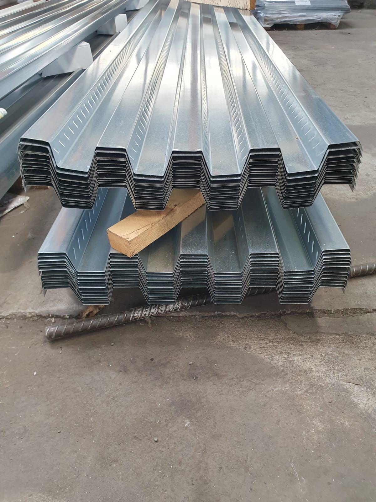 Pila di lastre di lamiera ondulata, colore grigio-argento, per l'edilizia.