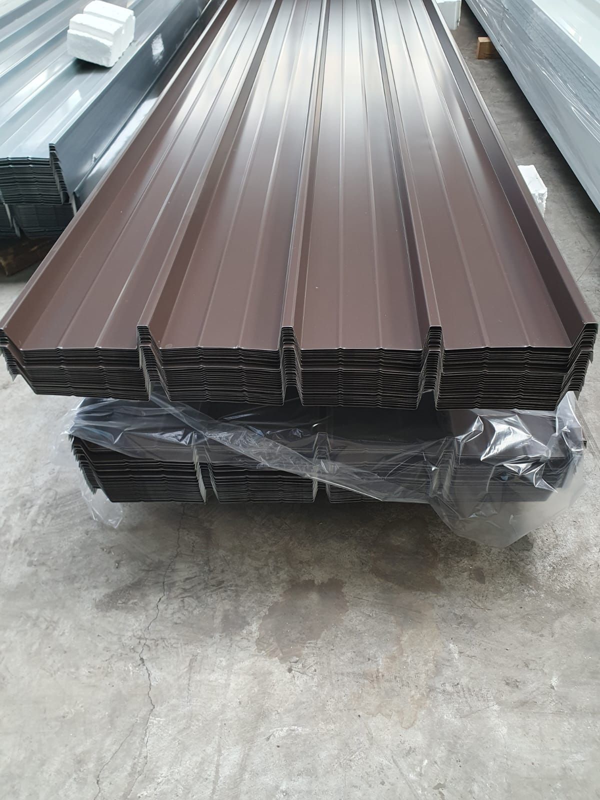 Pila di lastre di metallo ondulato marrone per coperture.