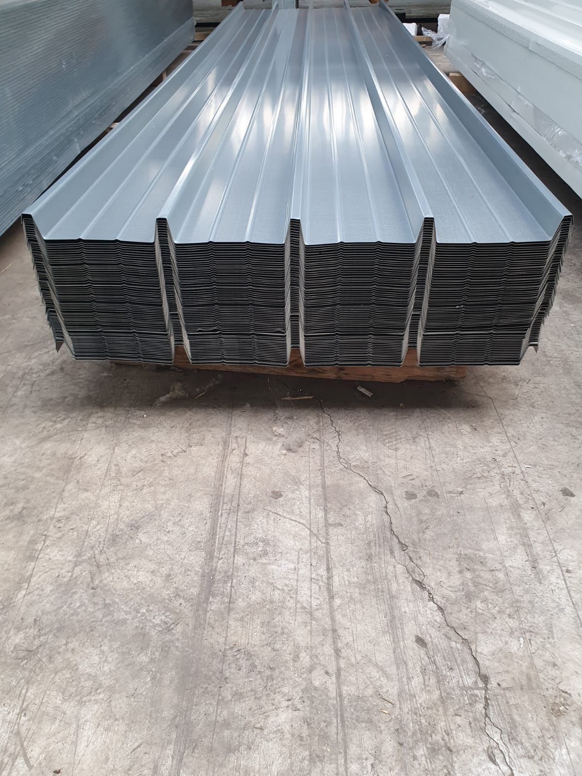 Pila di lamiere ondulate grigie su un pallet, pronte per l'uso.