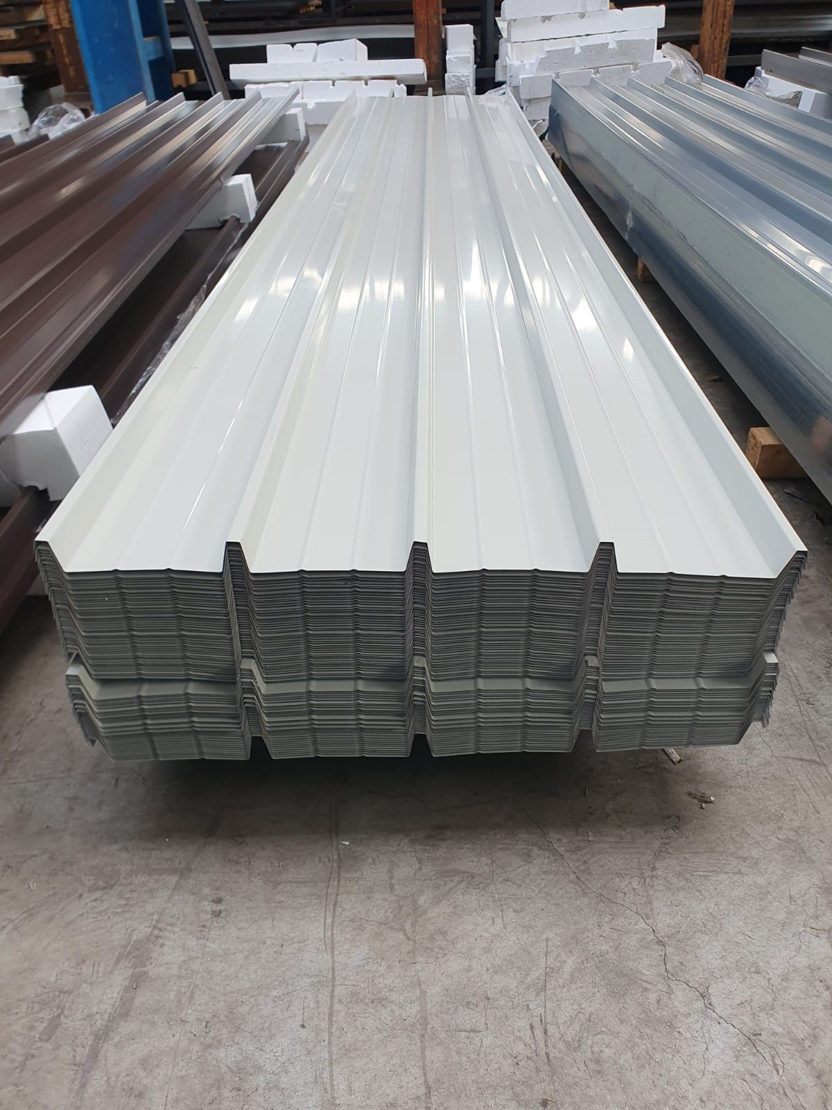 Pila di lastre di metallo ondulato bianco per coperture.