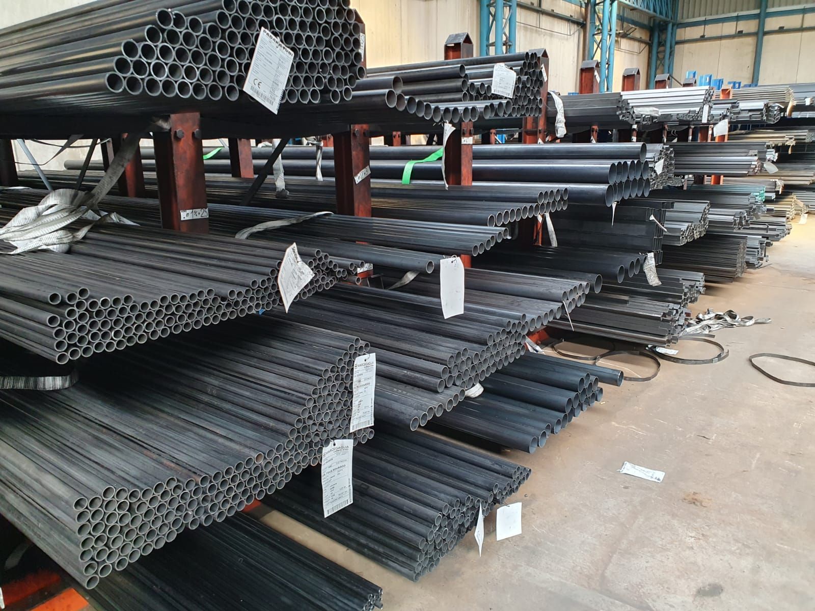 Tubi d'acciaio sistemati su scaffalature industriali.