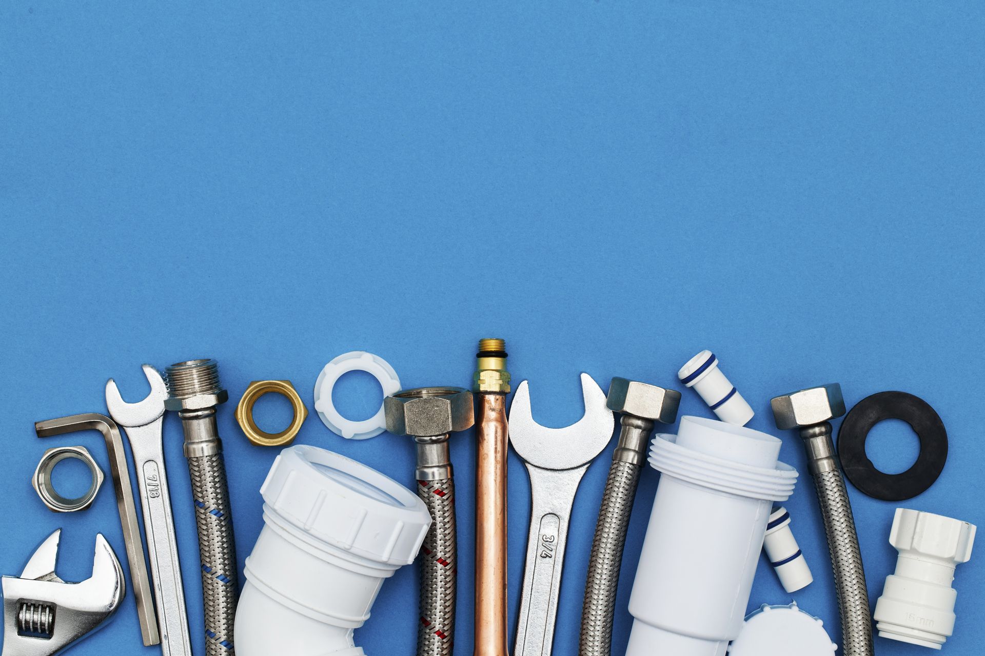 Plumbing tools and equipment on blue background  - Plumber in Mount Low, QLD