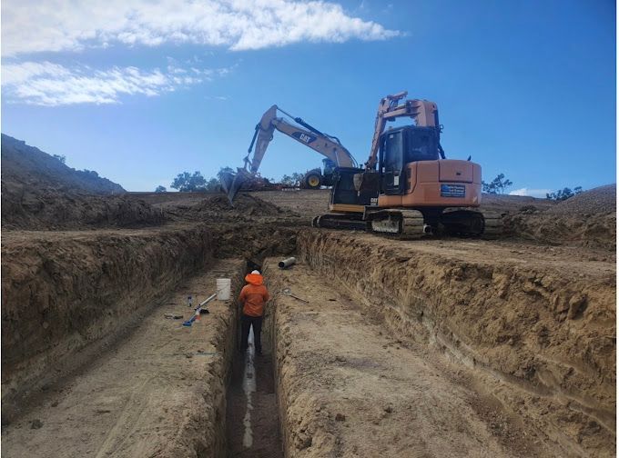 Excavator digging draining hole on a construction site - Plumber in Mount Low, QLD
