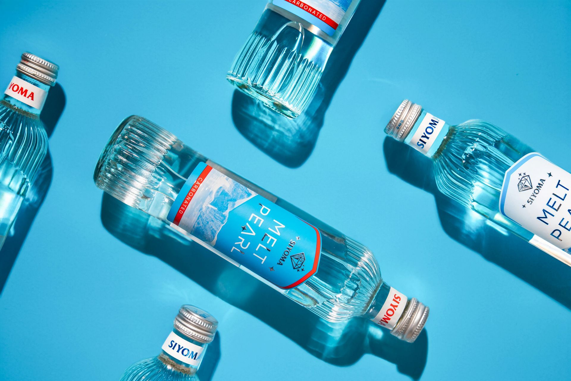 A group of bottles of water are sitting on top of each other on a blue surface.