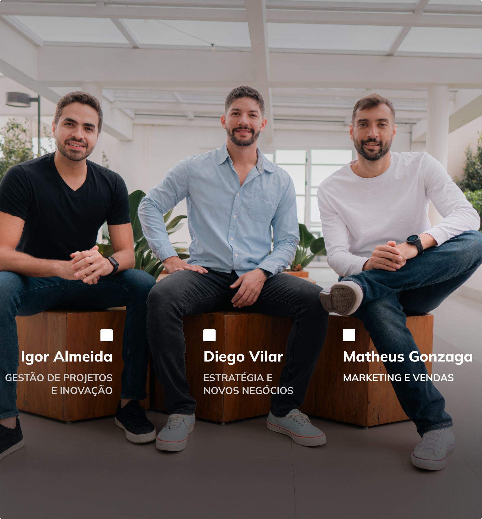 três homens estão sentados um ao lado do outro
