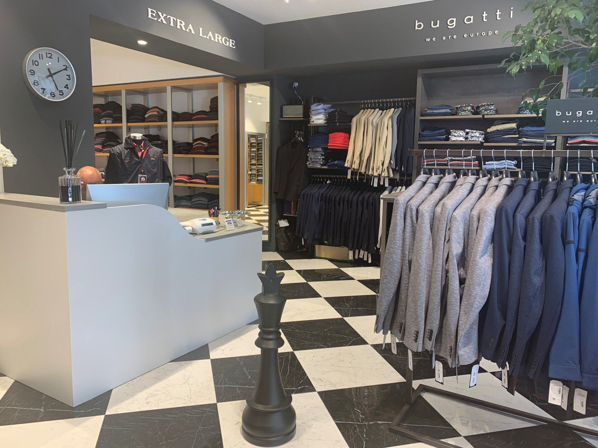 Un negozio di abbigliamento con un pavimento a scacchi e un pezzo degli scacchi al centro.