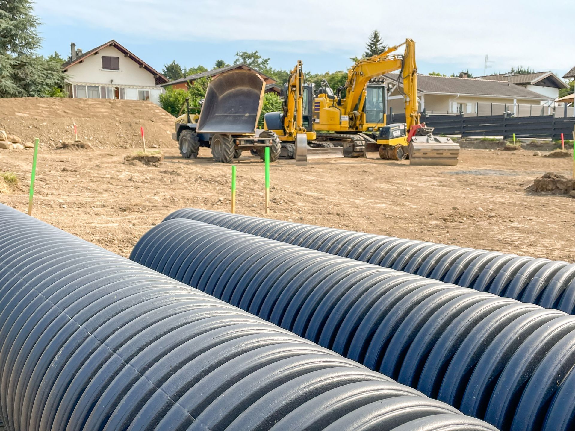 A construction site with a lot of pipes and tractors.