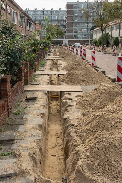 A trench is being dug on the side of a road.