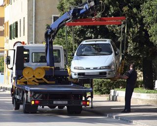 car being hoisted onto tow truck bed