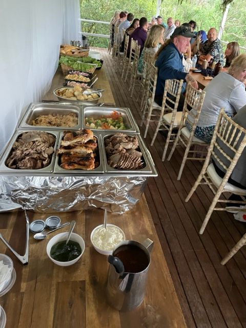 A Group Of People Are Sitting At Tables Eating Food From A Buffet — Tru Blu Catering In Sawtell, NSW