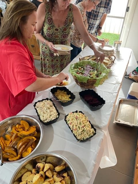 A Woman In A Red Shirt Is Serving Food At A Table — Tru Blu Catering In Coffs Harbour, NSW