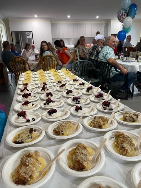 A Long Table With Plates Of Food And Spoons On It — Tru Blu Catering In Coffs Harbour, NSW